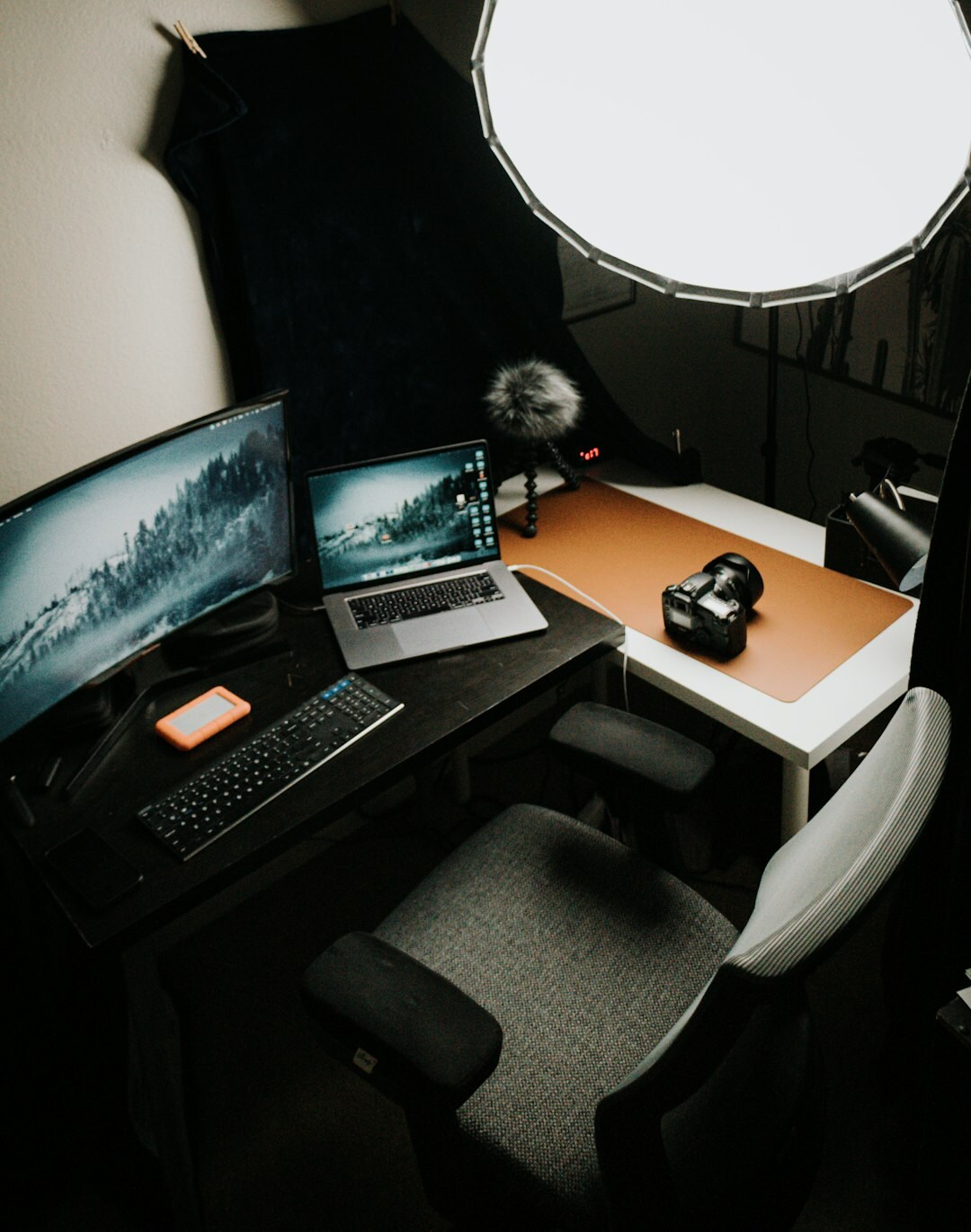 Modern video editing studio desk with multiple monitors