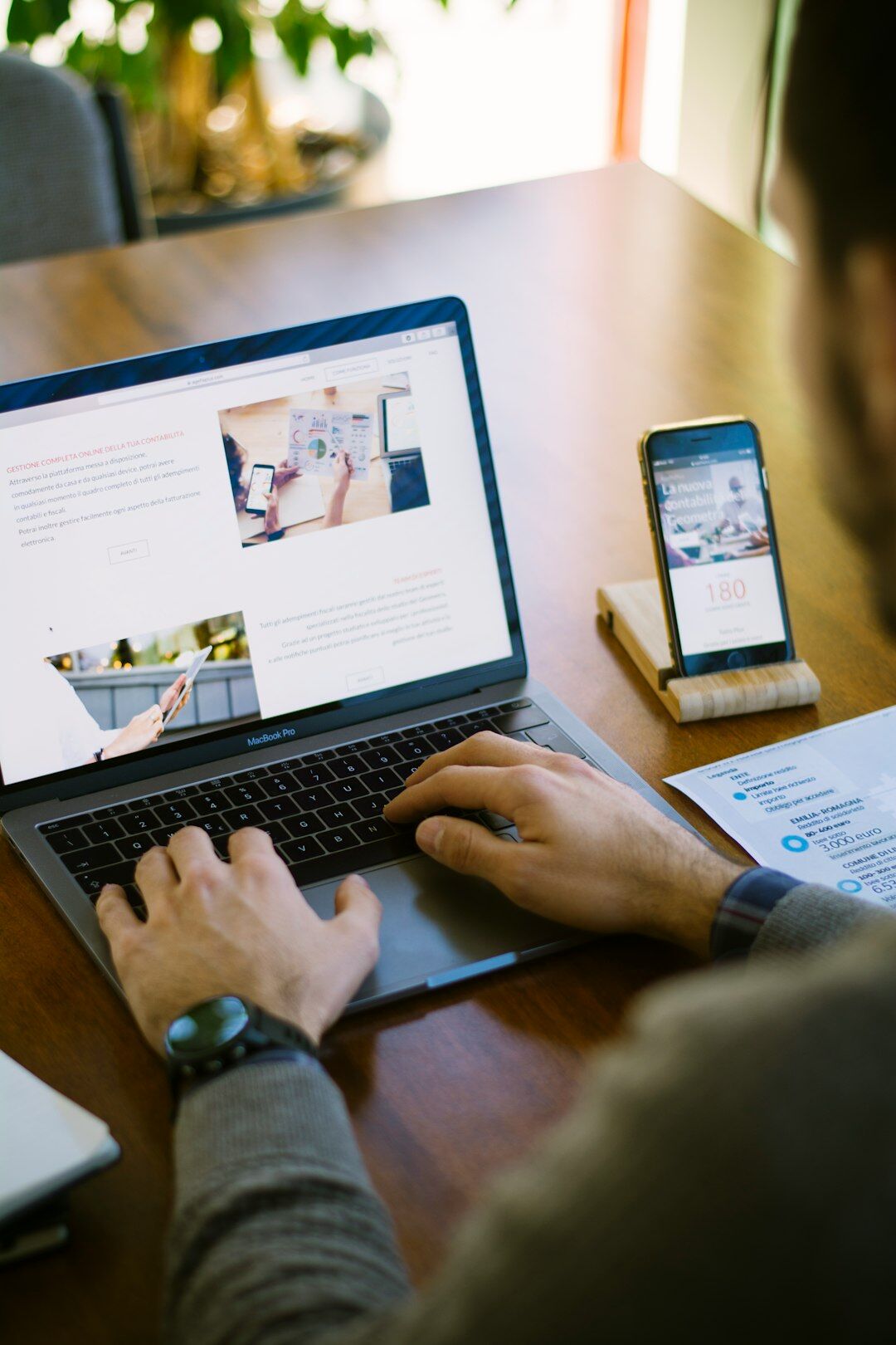 Person analyzing local news context on a laptop with notes